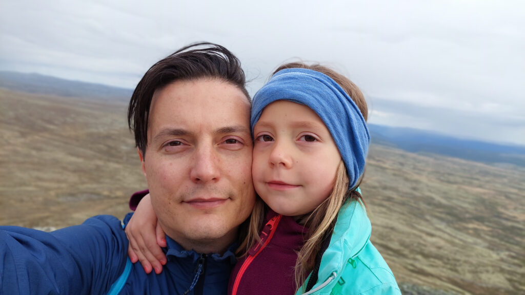 A selfie of a father and daughter on a summit hike in Norway.